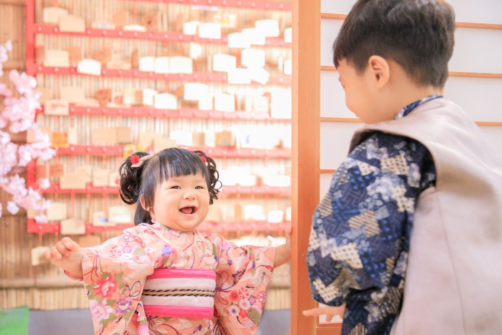 寶寶抓周拍攝花絮,穿著和服的兄妹互動畫面,妹妹開心對著哥哥微笑,呈現自然又溫馨的親子時光