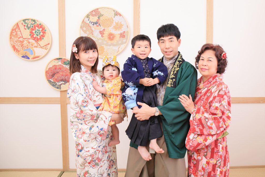 一家三代同堂的家庭合照，身穿傳統和服的家人們在日式背景前留下溫馨回憶。