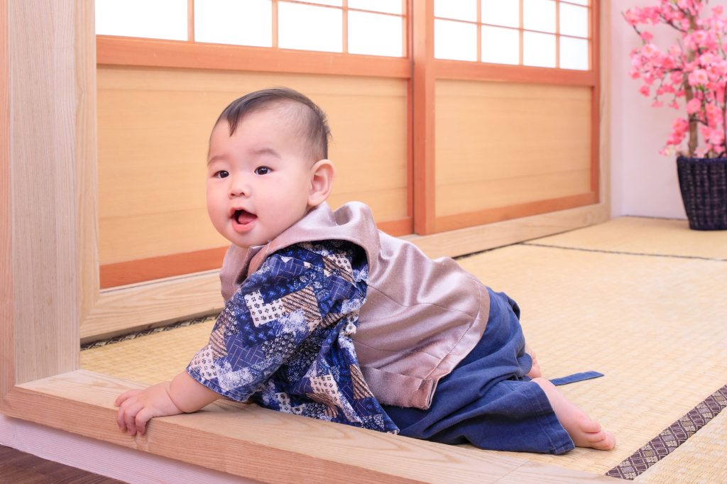 穿著日式服飾的寶寶在榻榻米上爬行,記錄抓周儀式中的可愛瞬間