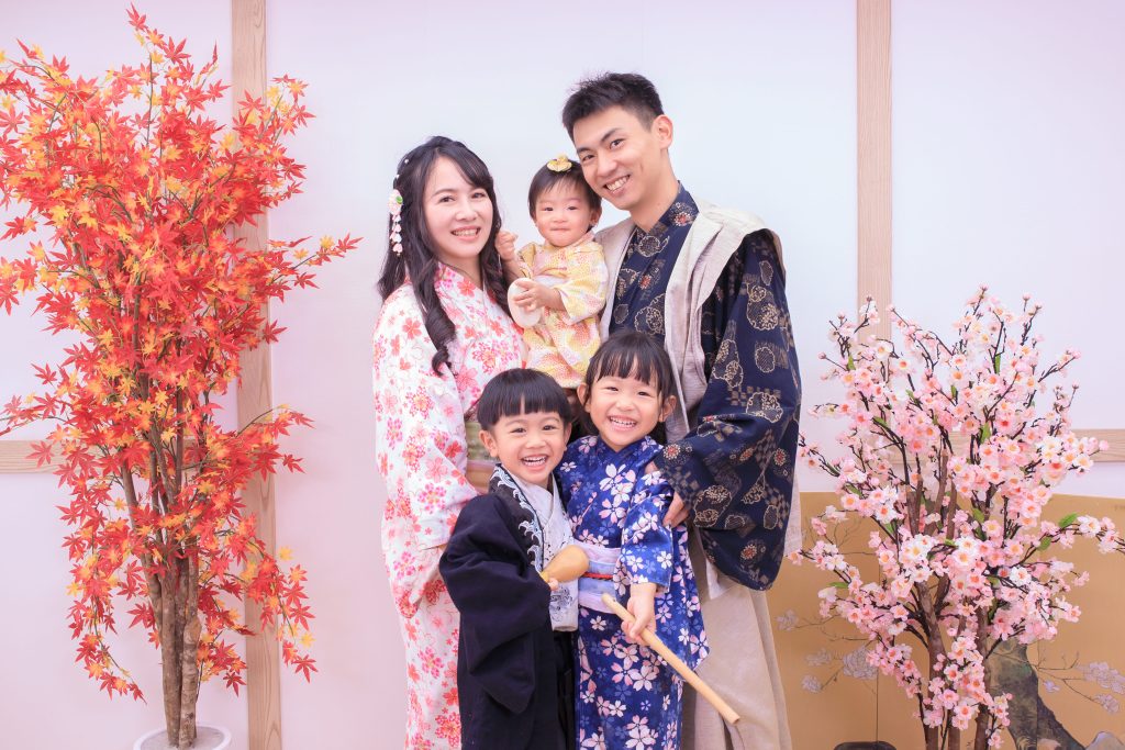 穿著日式和服的家庭在秋季楓葉與櫻花佈景下拍攝溫馨全家福照片